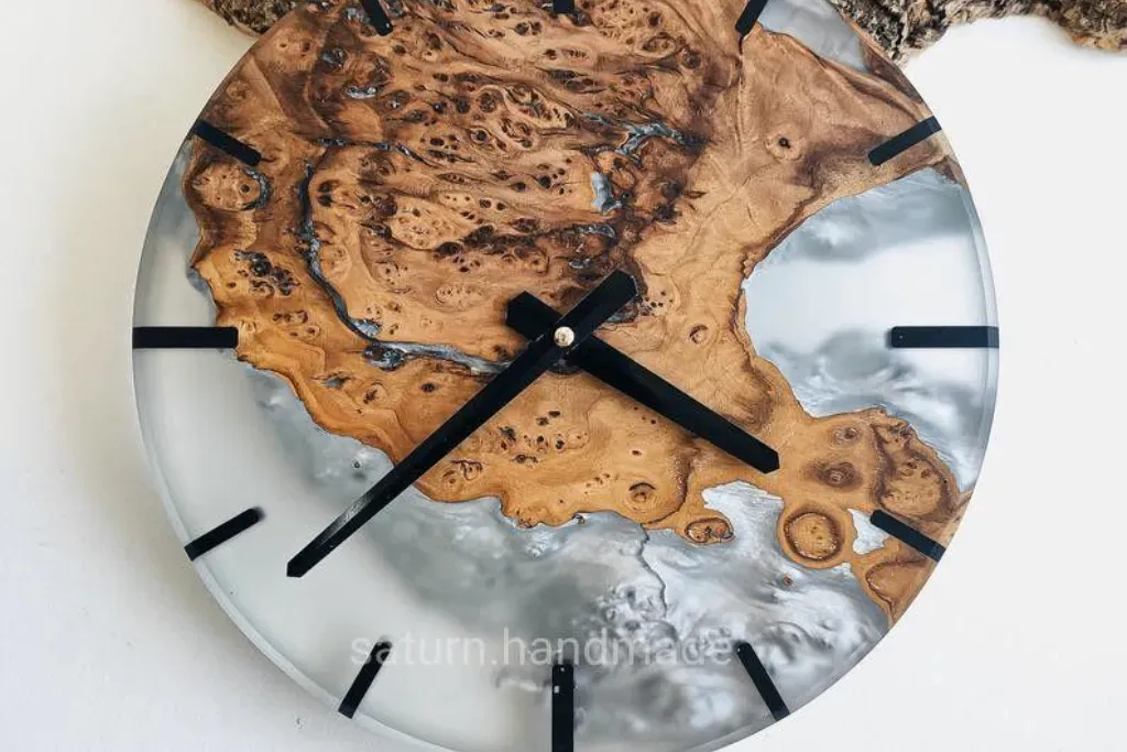 Round live-edge wood wall clock with swirling white and translucent epoxy resin.