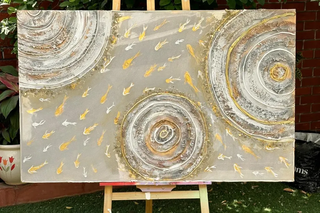 Large custom abstract painting on an easel, highlighting a silver and gold textured background with heavily layered plaster swirls and small gold koi fish detailing.